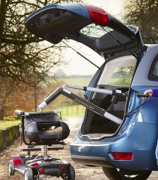 Grúa de maletero con mando cableado, recogiendo un escúter. Acceso a la galería. Abre nueva ventana